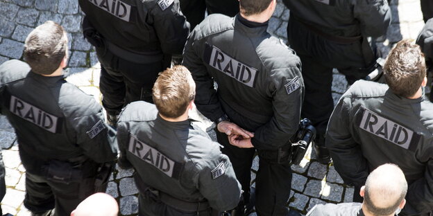 Raid Einsatzkräfte stehen auf einem Platz, von oben fotografiert Raid Einsatzkräfte stehen auf einem Platz, von oben fotografiert