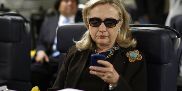 Hillary Clinton trägt eine Sonnenbrille und nutzt ihr Handy Hillary Clinton trägt eine Sonnenbrille und nutzt ihr Handy