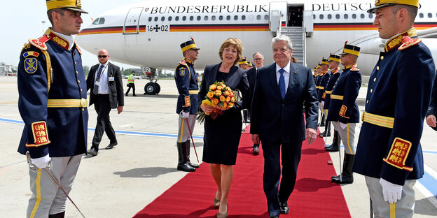 Bundespräsident Gauck und seine Lebensgefährtin laufen auf einem roten Teppich, dahinter ein Flugzeug, daneben Soldaten Bundespräsident Gauck und seine Lebensgefährtin laufen auf einem roten Teppich, dahinter ein Flugzeug, daneben Soldaten