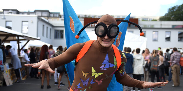 Ein Mensch in einem Schmetterlingskostüm lächelt Ein Mensch in einem Schmetterlingskostüm lächelt