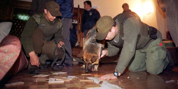 Polizisten mit einem Hund bei einer Spurensicherung Polizisten mit einem Hund bei einer Spurensicherung