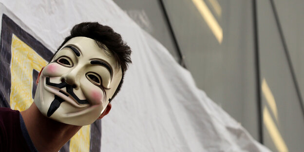 Jemand trägt eine Guy-Fawkes-Maske auf einer Demo in Madrid Jemand trägt eine Guy-Fawkes-Maske auf einer Demo in Madrid