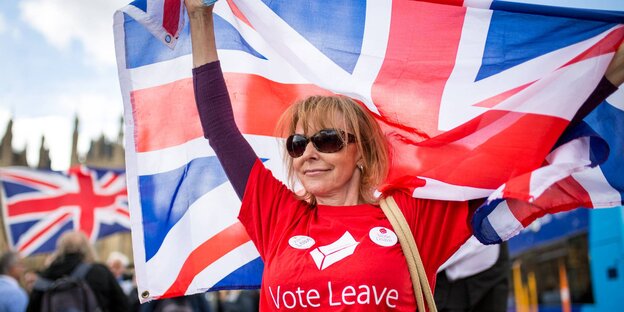 Eine Brexit-Befürworterin trägt eine Union-Jack-Flagge Eine Brexit-Befürworterin trägt eine Union-Jack-Flagge