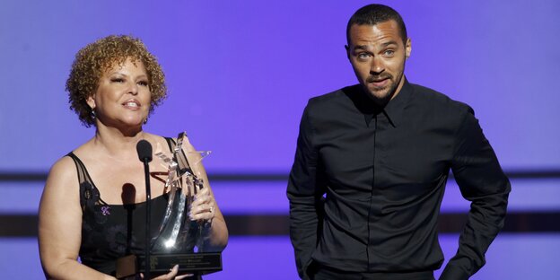 Debra Lee (links) und Jesse Williams auf der Bühne, Lee hält den Prieis noch in der Hand