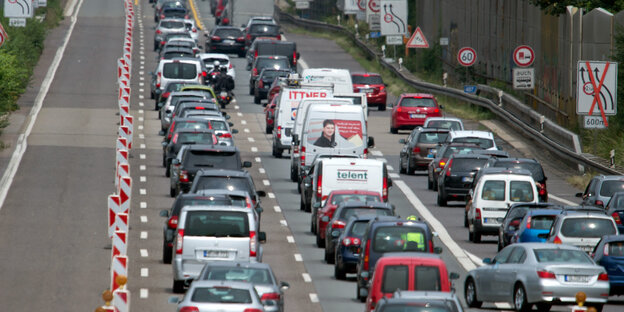 Auf einer dreispurigen Autobahn stehen Autos im Stau Auf einer dreispurigen Autobahn stehen Autos im Stau