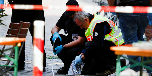 Polizisten kleben etwas auf den Boden Polizisten kleben etwas auf den Boden