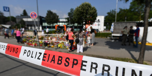 Blumen hinter einem Polizei-Absperrband Blumen hinter einem Polizei-Absperrband