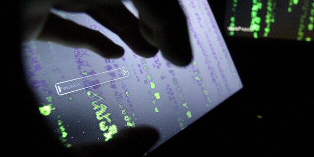 Die Silhouette einer Hand vor einem Monitor, darauf und im Hintergrund kryptische grüne Zeichenketten Die Silhouette einer Hand vor einem Monitor, darauf und im Hintergrund kryptische grüne Zeichenketten