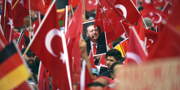 Ein Plakat von Erdogan ist umgegeben von türkischen Flaggen Ein Plakat von Erdogan ist umgegeben von türkischen Flaggen