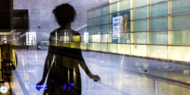 Eine Silhouette spiegelt sich in einer Glasfassade Eine Silhouette spiegelt sich in einer Glasfassade
