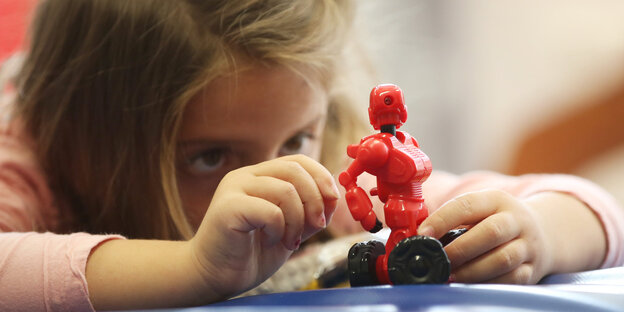 Ein Mädchen spielt mit einer Figur Ein Mädchen spielt mit einer Figur