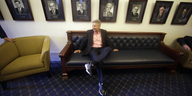 Ein Mann mit Turnschuhen sitzt auf einem Sofa. Es ist Gary Johnson Ein Mann mit Turnschuhen sitzt auf einem Sofa. Es ist Gary Johnson