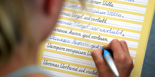 Eine Grundschülerin übt Schreibschrift Eine Grundschülerin übt Schreibschrift