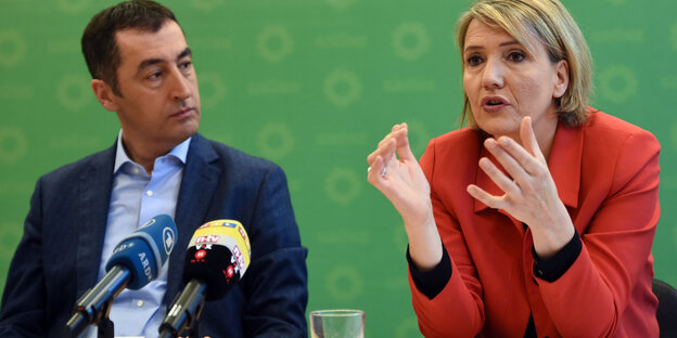 Ein Mann und eine Frau sitzen auf einem Podium Ein Mann und eine Frau sitzen auf einem Podium
