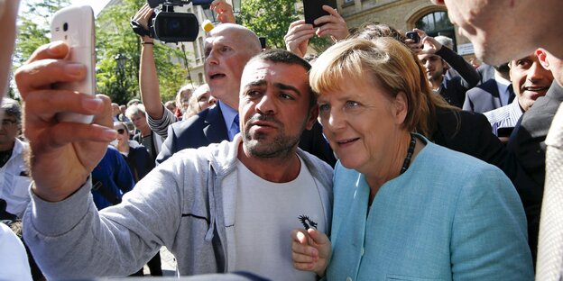 Ein Migrant macht ein Selfie mit Angela Merkel Ein Migrant macht ein Selfie mit Angela Merkel