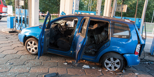 ein Auto mit explodiertem Tank in Blau an einer Tankstelle ein Auto mit explodiertem Tank in Blau an einer Tankstelle
