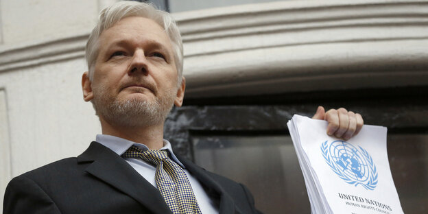 Julian Assange hält den UN-Bericht in der Hand Julian Assange hält den UN-Bericht in der Hand