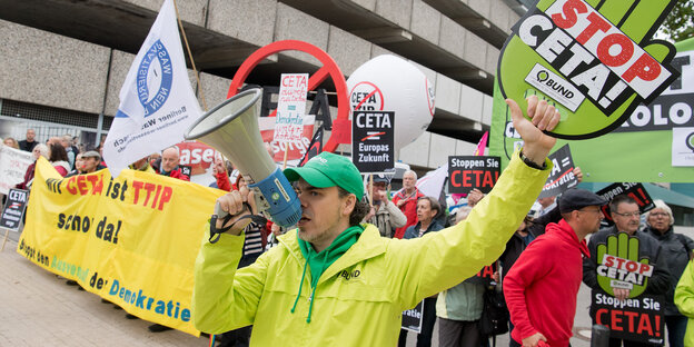 Demonstranten vor dem Tagungsgebäude der SPD, im Vordergrund ein Demonstrant mit Megaphon vor dem Mund Demonstranten vor dem Tagungsgebäude der SPD, im Vordergrund ein Demonstrant mit Megaphon vor dem Mund