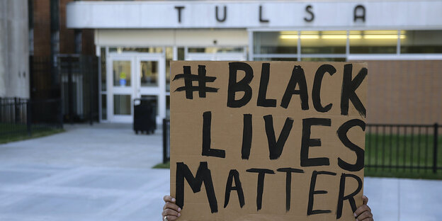 Ein Demonstrant mit einem Black-Lives-Matters-Shirt ruft durch ein Megafon Ein Demonstrant mit einem Black-Lives-Matters-Shirt ruft durch ein Megafon