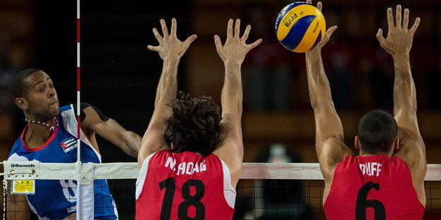 Drei Volleyballspieler während eines Spiels Drei Volleyballspieler während eines Spiels