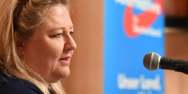 Profil einer Frau. Im Hintergrund hängt ein AfD-Wahlplakat Profil einer Frau. Im Hintergrund hängt ein AfD-Wahlplakat