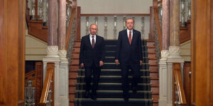 Zwei anzugtragende Männer gehen nebeneinander eine Treppe hinunter