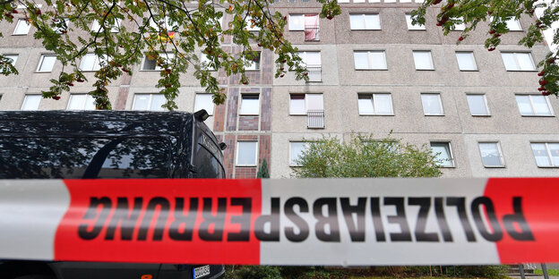 Polizei-Absperrband vor einem mehrstöckigen Wohnhaus Polizei-Absperrband vor einem mehrstöckigen Wohnhaus