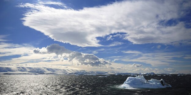 Ein Meer mit Eisbergen, der Himmel ist teilweise bewölkt Ein Meer mit Eisbergen, der Himmel ist teilweise bewölkt