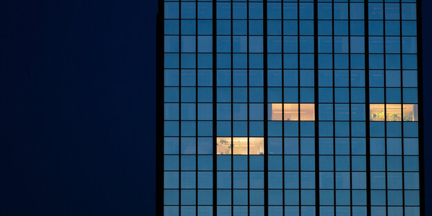 In einem Bürohochhaus leuchten nachts noch drei Büros In einem Bürohochhaus leuchten nachts noch drei Büros