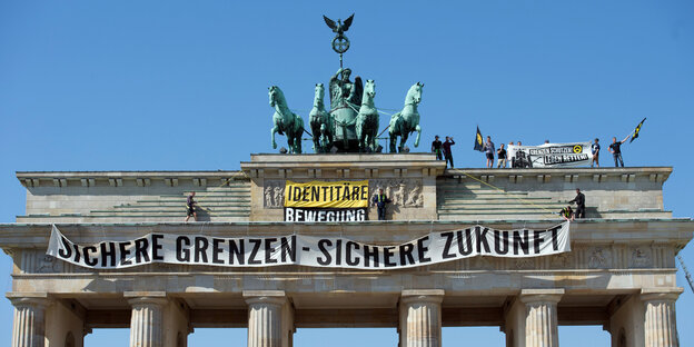 Aktivisten der „Identitären Bewegung“ stehen auf dem Brandenburger Tor und haben ein Banner mit der Aufschrift „Sichere Grenzen – Sichere Zukunft“ aufgehängt“ Aktivisten der „Identitären Bewegung“ stehen auf dem Brandenburger Tor und haben ein Banner mit der Aufschrift „Sichere Grenzen – Sichere Zukunft“ aufgehängt“