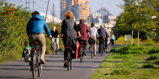 Eine Gruppe Fahrradfahrer fährt durch den Berliner Gleisdreieckspark auf den Potsdamer Platz zu Eine Gruppe Fahrradfahrer fährt durch den Berliner Gleisdreieckspark auf den Potsdamer Platz zu
