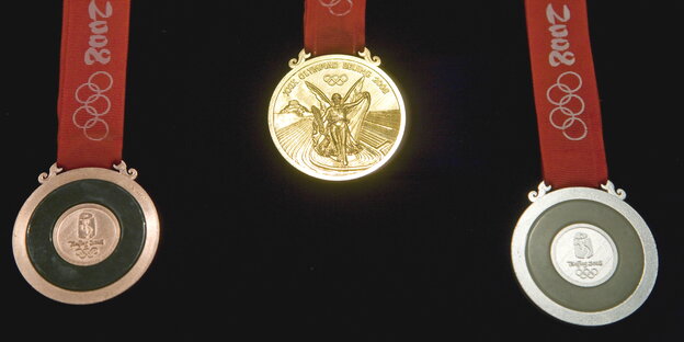 ein Satz Olympiamedaillen an roten Bändern ein Satz Olympiamedaillen an roten Bändern