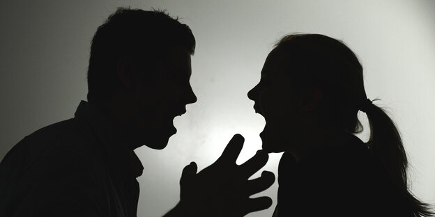 die schwarz-weiße Silhouette eines Mannes und einer Frau, die sich anschreihen die schwarz-weiße Silhouette eines Mannes und einer Frau, die sich anschreihen