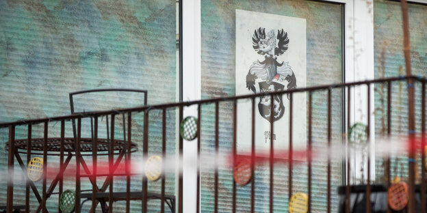 Ein Balkon ist zu sehen. Darauf ein Plakat mit einem Wappen und einem Bären Ein Balkon ist zu sehen. Darauf ein Plakat mit einem Wappen und einem Bären