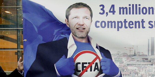 ein Mann mit Stop-Ceta auf der Brust in Superheldenpose ein Mann mit Stop-Ceta auf der Brust in Superheldenpose