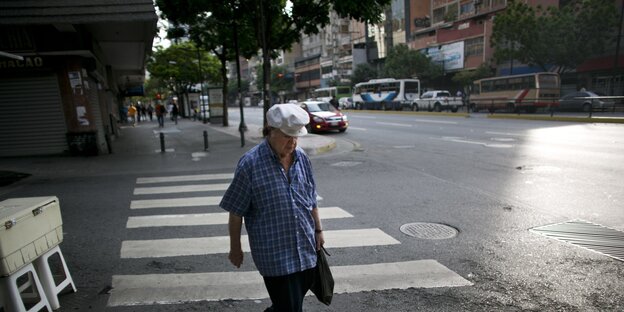 Eine Frau geht durch die leeren Straßen von Caracas Eine Frau geht durch die leeren Straßen von Caracas
