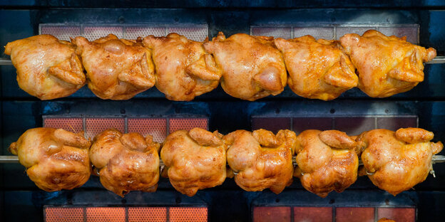 Gegrillte Hähnchen an einer Grillstange im Imbiss Gegrillte Hähnchen an einer Grillstange im Imbiss