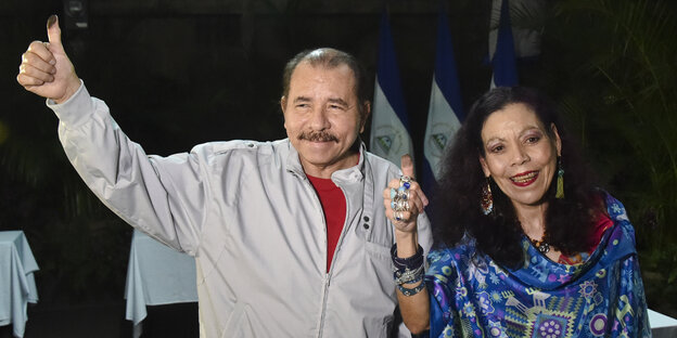 Daniel Ortega und seine Frau zeigen den Daumen nach oben, auf diesem ist Stempelfarbe Daniel Ortega und seine Frau zeigen den Daumen nach oben, auf diesem ist Stempelfarbe
