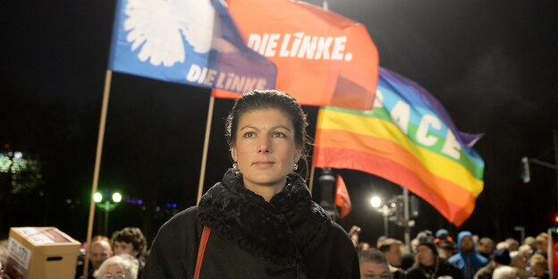 Sarah Wagenknecht steht bei einer Kundgebung vor einer Die Linke-Flagge und einer LGBTQ-Flagge Sarah Wagenknecht steht bei einer Kundgebung vor einer Die Linke-Flagge und einer LGBTQ-Flagge