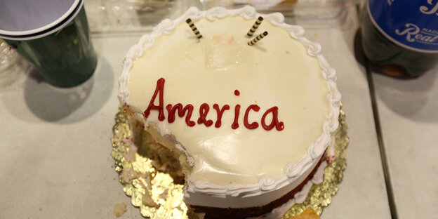 Ein Kuchen mit weißer Glasur, an einer Ecke angebissen Ein Kuchen mit weißer Glasur, an einer Ecke angebissen