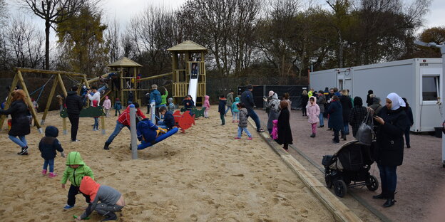 Kinder spielen auf dem neuen Spielplatz neben den Wohncontainern der Erstaufnahme an der Hamburger Papenreye. Kinder spielen auf dem neuen Spielplatz neben den Wohncontainern der Erstaufnahme an der Hamburger Papenreye.