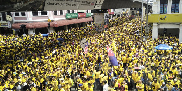 Menschen protestieren in gelben T-Shirts gegen den Premierminister von Malaysia Menschen protestieren in gelben T-Shirts gegen den Premierminister von Malaysia