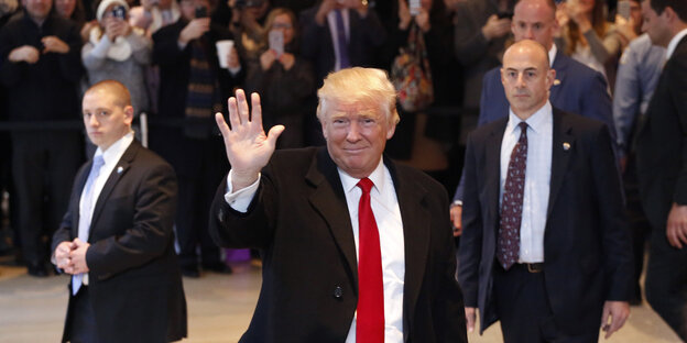 Donald Trump geht durch das Foyer der New York Times und winkt Donald Trump geht durch das Foyer der New York Times und winkt