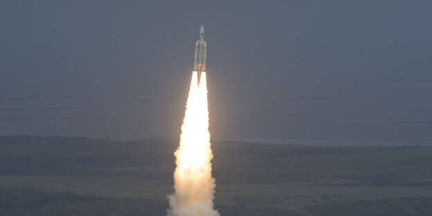 Eine Rakete steigt in den dunklen Himmel und zieht einen Feuerschweif nach sich Eine Rakete steigt in den dunklen Himmel und zieht einen Feuerschweif nach sich