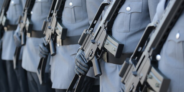 Soldaten, die Sturmgewehren vor dem Bauch tragen Soldaten, die Sturmgewehren vor dem Bauch tragen