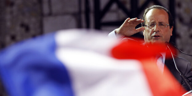 Hollande winkt hinter einer großen französischen Flagge Hollande winkt hinter einer großen französischen Flagge