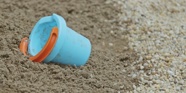 Ein Eimer liegt im Sand Ein Eimer liegt im Sand