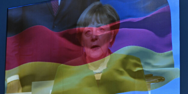 Merkel und eine Deutschlandfahne auf einem Bildschirm Merkel und eine Deutschlandfahne auf einem Bildschirm