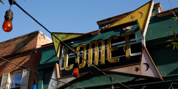 Das gelbe Logo der Pizzeria "Comet Ping Pong". Um den Schriftzug "Comet" befinden sich Steren und Monde. Das gelbe Logo der Pizzeria "Comet Ping Pong". Um den Schriftzug "Comet" befinden sich Steren und Monde.