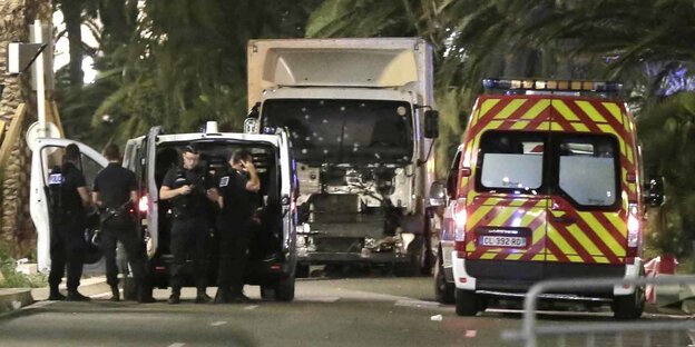 Polizisten stehen in der Nähe eines Lkw, dessen Frontscheibe mit Einschusslöchern übersäht ist Polizisten stehen in der Nähe eines Lkw, dessen Frontscheibe mit Einschusslöchern übersäht ist